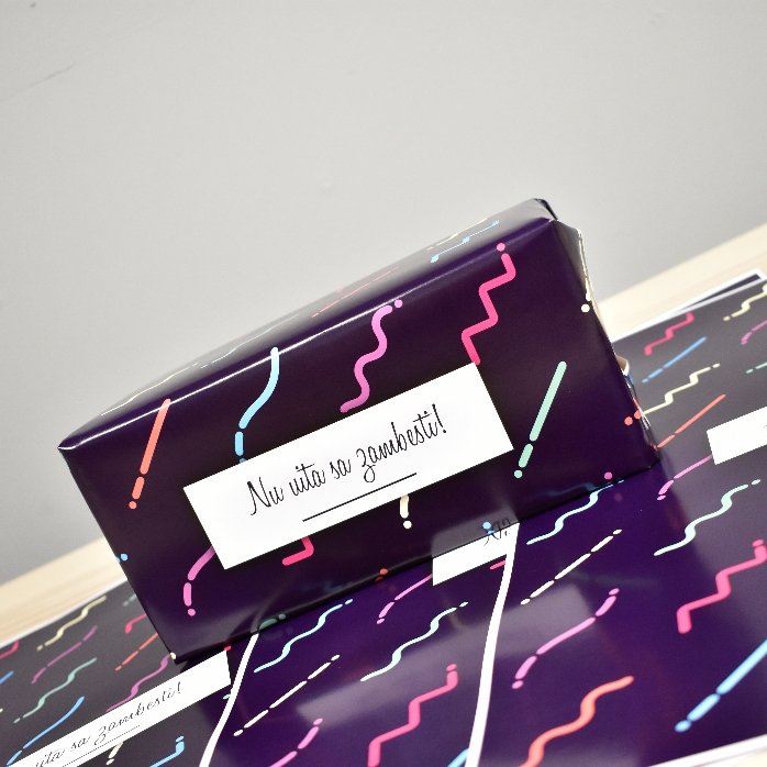 Gepersonaliseerd cadeaupapier met tekst in een kader, donkerpaarse achtergrond