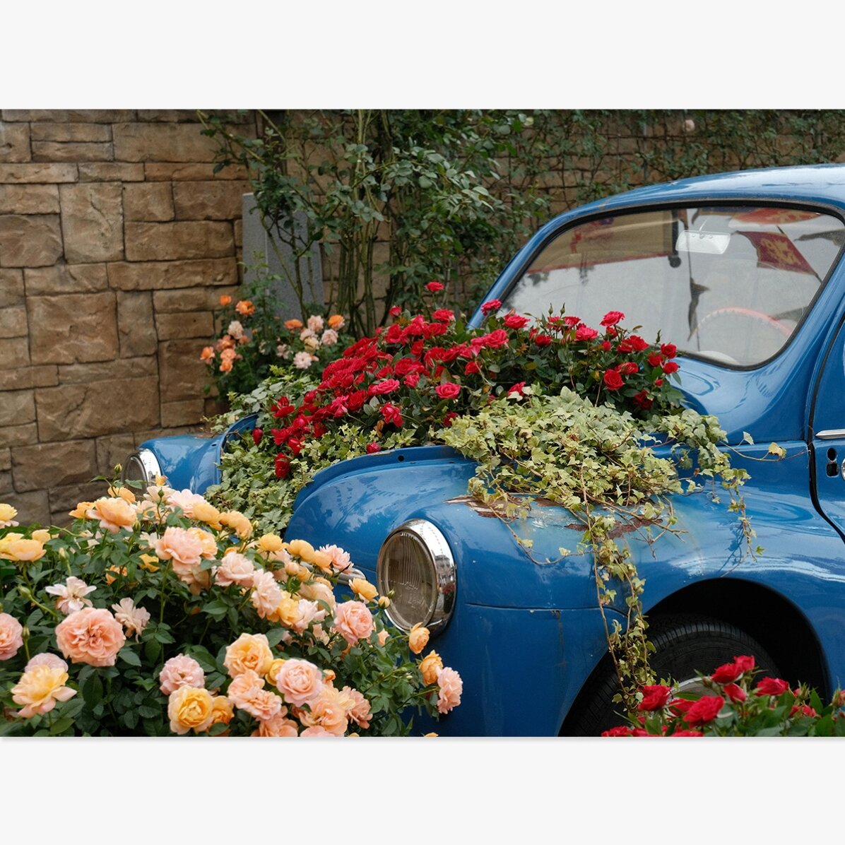 Poster: Vintage blauwe auto met bloemen